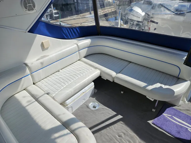 Slide: The Image of 2006 Bayliner 305 interior with white leather seating and blue accents. - 17