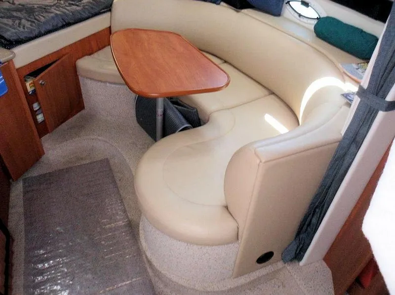 Slide: The Image of Interior of 2006 Bayliner 305 boat with beige seating and wooden table. - 18