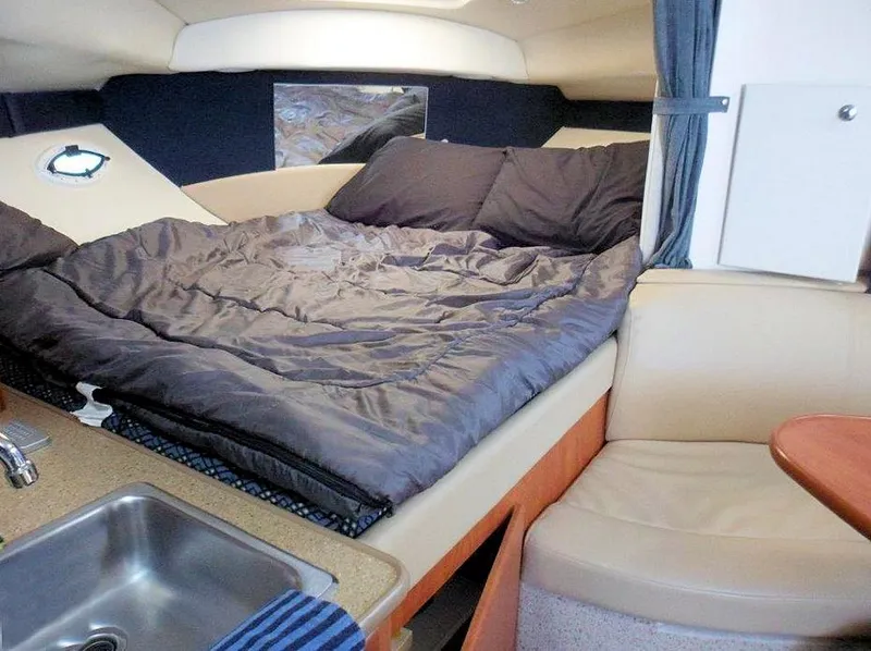Slide: The Image of Interior of 2006 Bayliner 305 boat with cozy sleeping area and compact kitchenette. - 4