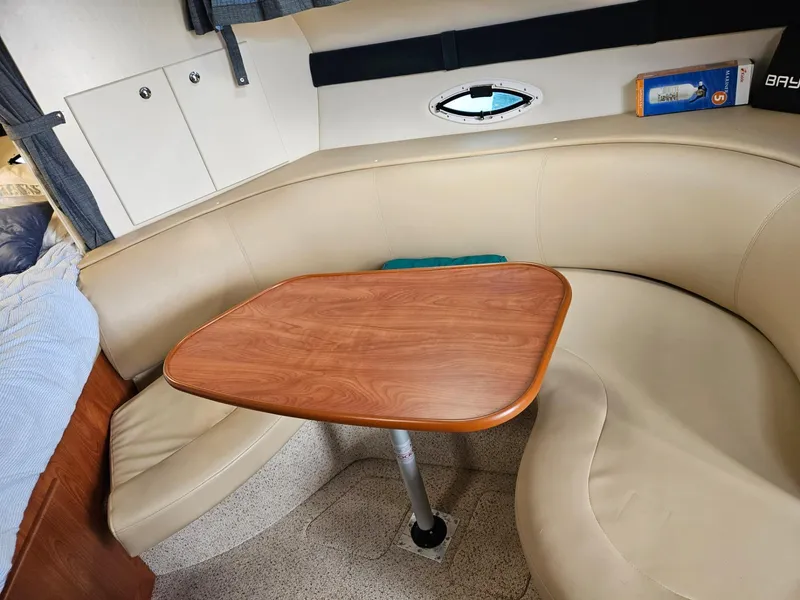 Slide: The Image of 2006 Bayliner 305 interior with beige leather seating and wooden table. - 7