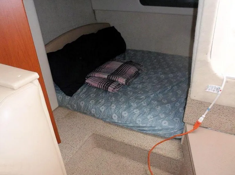 Slide: The Image of 2006 Bayliner 305 cabin interior with bed, pillows, and blanket. - 9