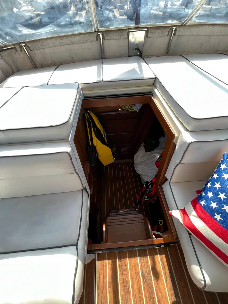Slide: The Image of 1987 Scand Baltic boat interior with white seating and American flag pillow. - 11