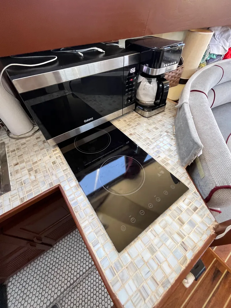 Slide: The Image of 1987 Scand Baltic kitchen with modern appliances, microwave, coffee maker, and induction cooktop. - 15