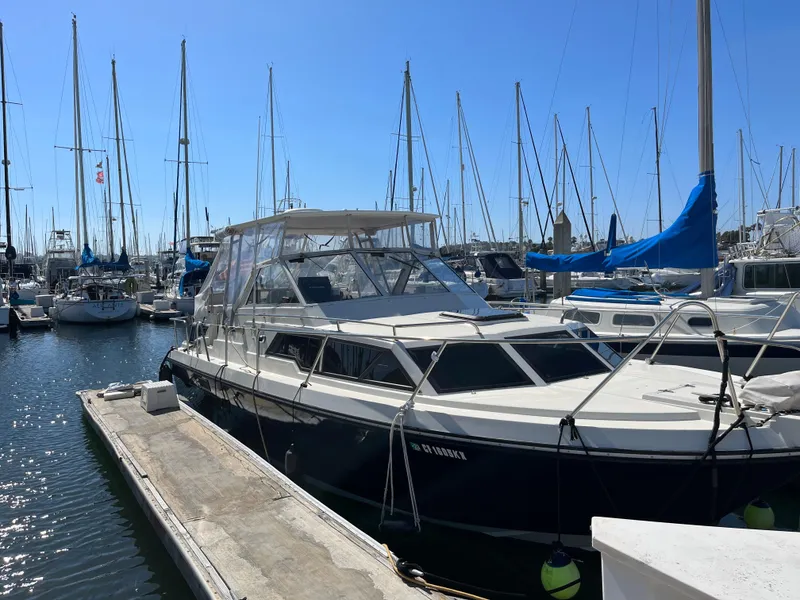 Slide: The Image of 1987 Scand Baltic boat docked at a marina with sailboats in the background. - 2