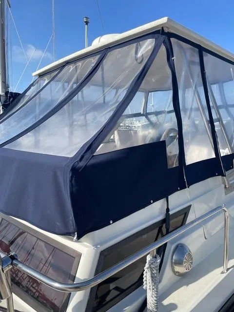 Slide: The Image of 1987 Scand Baltic boat with blue canopy and clear windows in marina. - 7