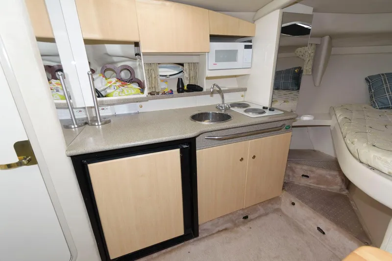 Slide: The Image of 2000 Formula 31 PC boat interior kitchen with sink, microwave, and mini-fridge. - 12