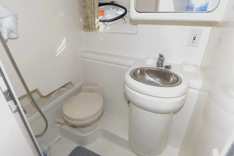 Slide: The Image of Compact bathroom in a 2000 Formula 31 PC boat with sink, toilet, and shower. - 18