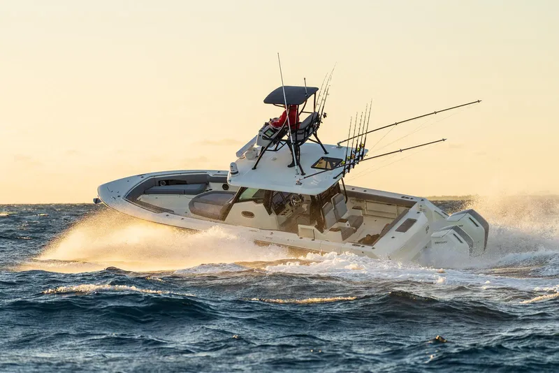 Slide: The Image of 2024 Boston Whaler 360 Outrage navigating rough seas at sunset. - 12