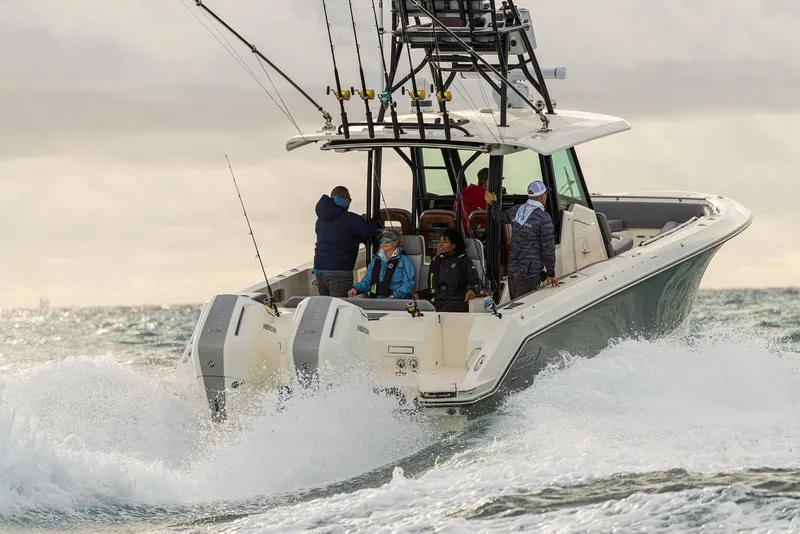 Slide: The Image of 2024 Boston Whaler 360 Outrage navigating choppy waters with passengers onboard. - 18