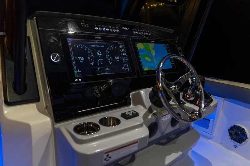Slide: The Image of 2024 Boston Whaler 360 Outrage dashboard with advanced navigation displays and controls. - 3
