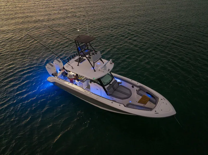 Slide: The Image of 2024 Boston Whaler 360 Outrage boat illuminated on calm water at dusk. - 8
