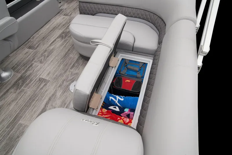 Slide: The Image of 2024 Ranger Reata 223FC boat with open storage compartment under cushioned seating. - 45