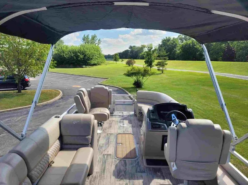 Slide: The Image of 2024 Ranger Reata 223FC pontoon boat interior with seating and steering console. - 5