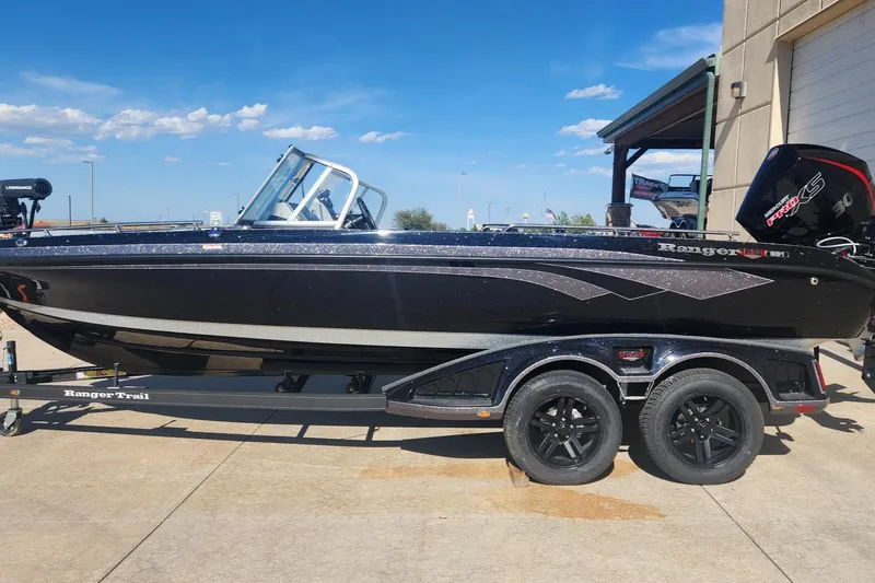 Slide: The Image of 2024 Ranger 621FS Ranger Cup Equipped boat on trailer, black exterior, parked outdoors. - 2