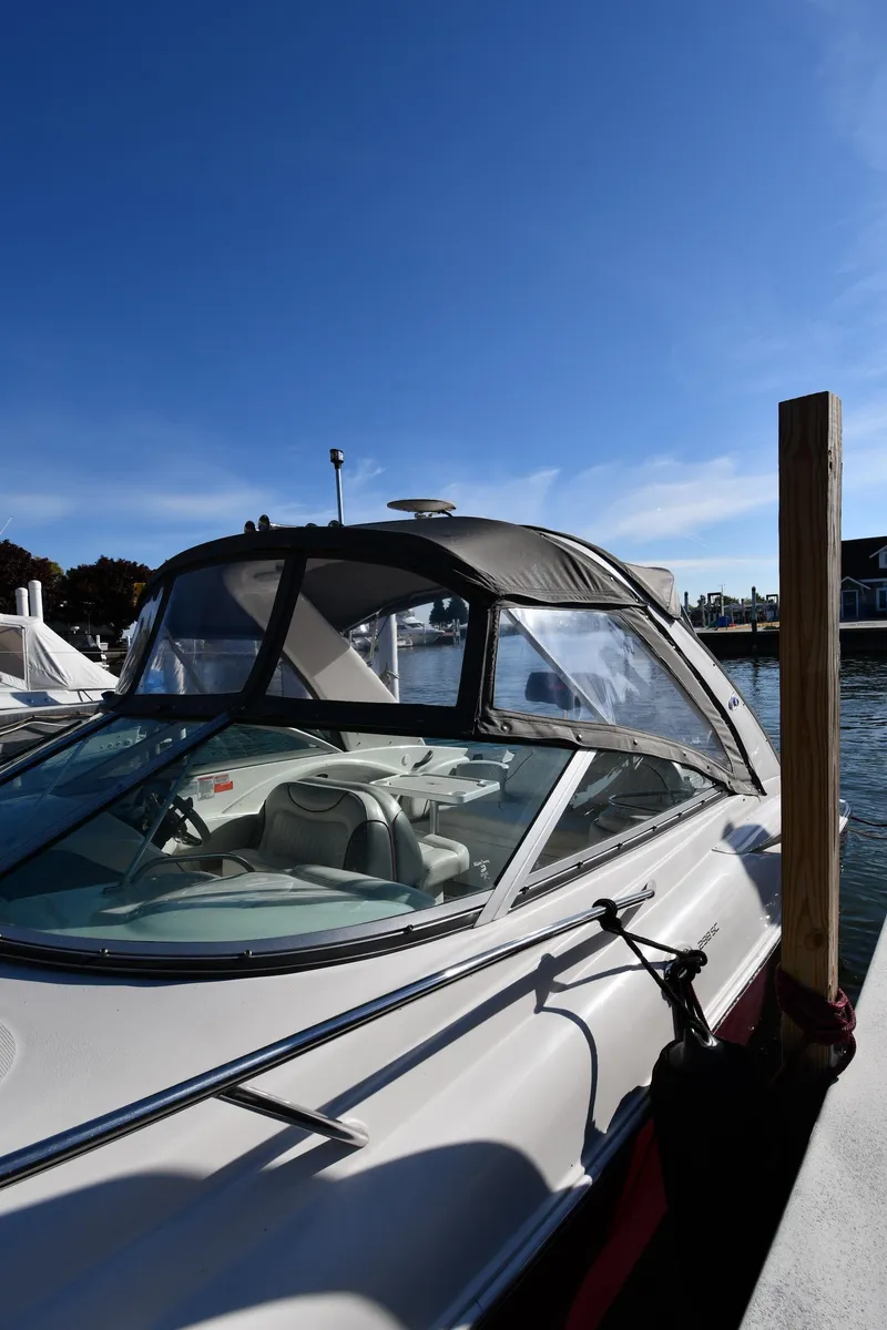 Slide: The Image of 2006 Monterey 298SC Super Sport boat with gray cover docked at marina. - 2