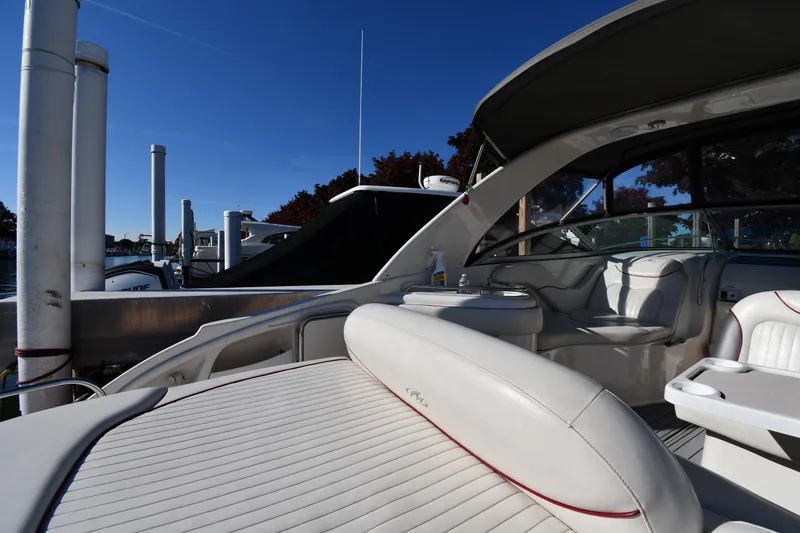 Slide: The Image of 2006 Monterey 298SC Super Sport boat interior with seating and table, docked by a marina. - 24