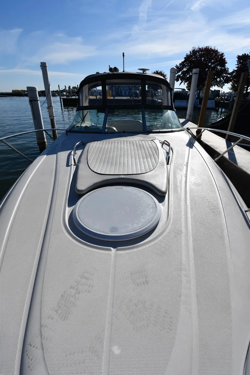 Slide: The Image of 2006 Monterey 298SC Super Sport boat docked at marina, surrounded by trees and calm water. - 5