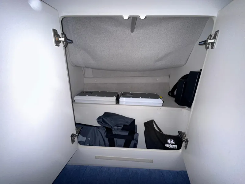 Slide: The Image of Storage compartment inside a 1994 Carver 340 Santego boat, featuring organized shelves and bags. - 18