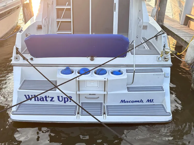 Slide: The Image of 1994 Carver 340 Santego boat docked, rear view, with "What'z Up?" text, Macomb, MI. - 2