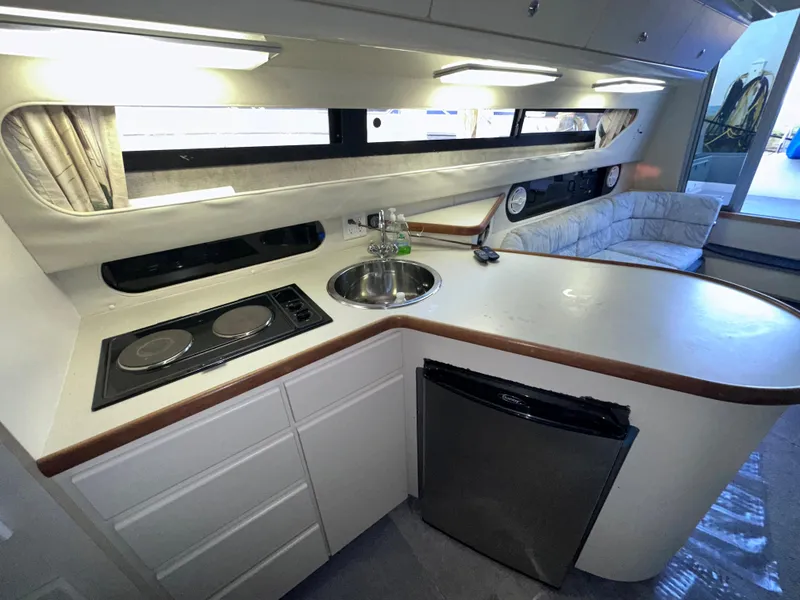 Slide: The Image of 1994 Carver 340 Santego yacht interior with kitchenette, stove, sink, and seating area. - 28