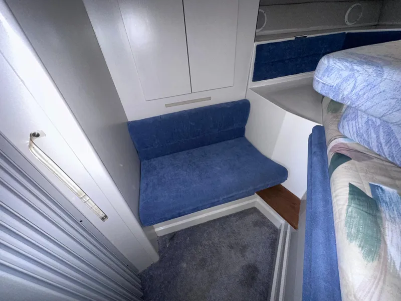 Slide: The Image of 1994 Carver 340 Santego interior with blue seating and storage cabinets. - 19