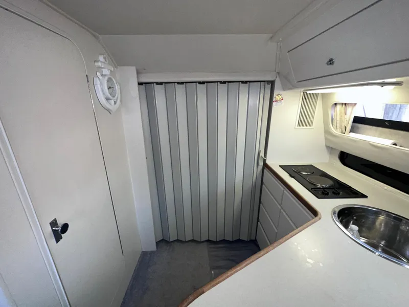 Slide: The Image of 1994 Carver 340 Santego interior with compact kitchen, stove, sink, and storage cabinets. - 20