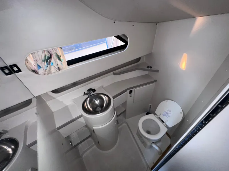 Slide: The Image of 1994 Carver 340 Santego yacht bathroom with sink, toilet, and window. - 21