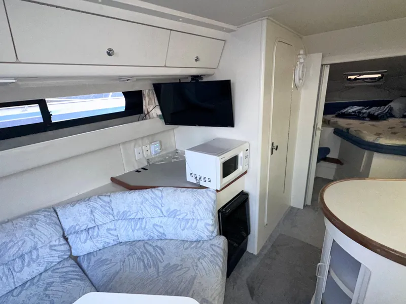 Slide: The Image of Interior of a 1994 Carver 340 Santego yacht with seating, TV, and kitchenette. - 23