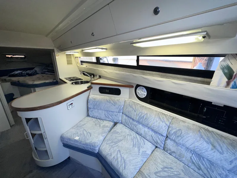 Slide: The Image of 1994 Carver 340 Santego yacht interior with cozy seating and kitchenette. - 26