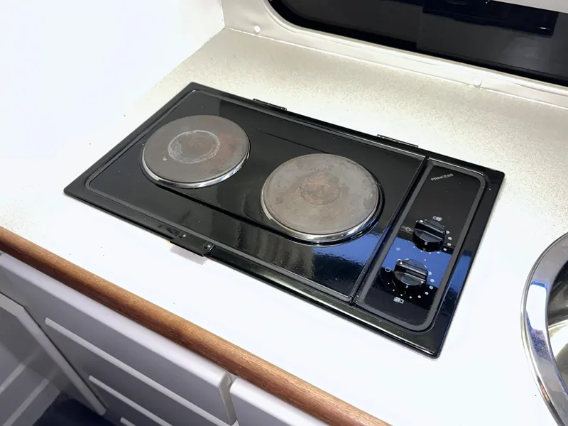 Slide: The Image of Electric stove in 1994 Carver 340 Santego yacht kitchen, featuring dual burners and control knobs. - 29