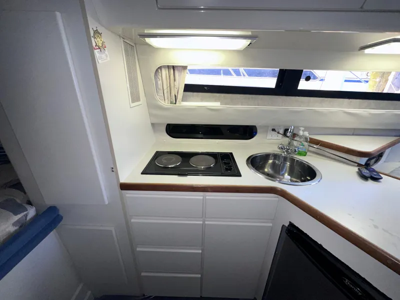Slide: The Image of 1994 Carver 340 Santego yacht kitchen with stove, sink, and cabinets. - 30