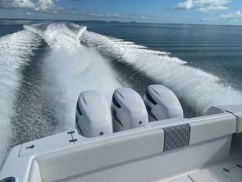 Slide: The Image of 2001 Intrepid 377 Walkaround boat with triple engines cruising on open water. - 16