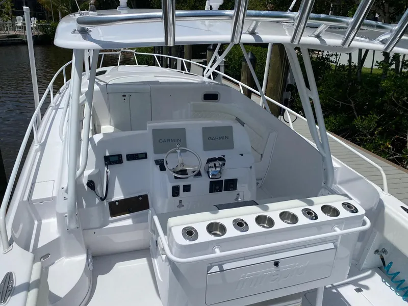 Slide: The Image of 2001 Intrepid 377 Walkaround boat with sleek white deck and modern controls. - 19