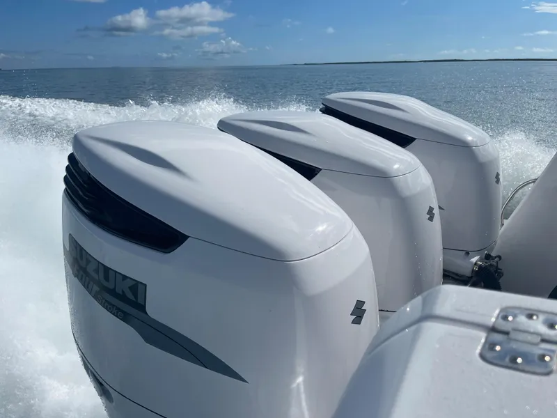 Slide: The Image of Triple Suzuki outboard engines powering a 2001 Intrepid 377 Walkaround on open water. - 2