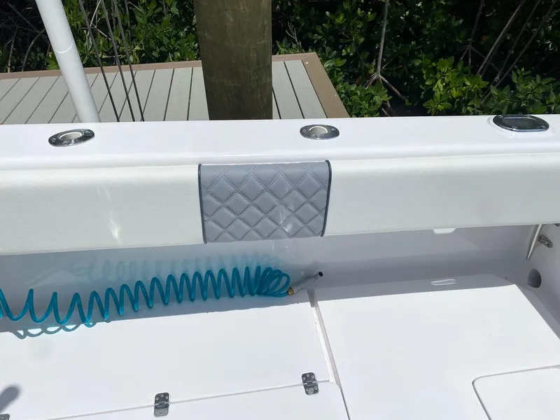 Slide: The Image of 2001 Intrepid 377 Walkaround boat deck with padded railing and coiled blue hose. - 21