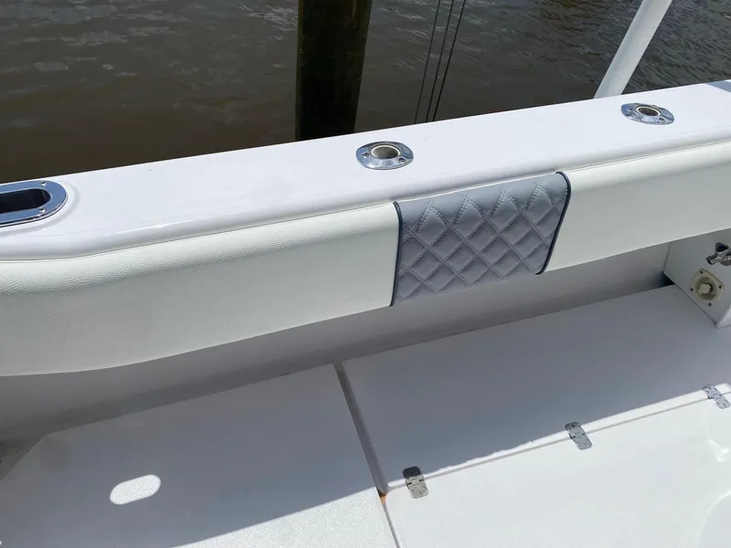 Slide: The Image of 2001 Intrepid 377 Walkaround boat interior with cushioned seating and rod holders. - 23