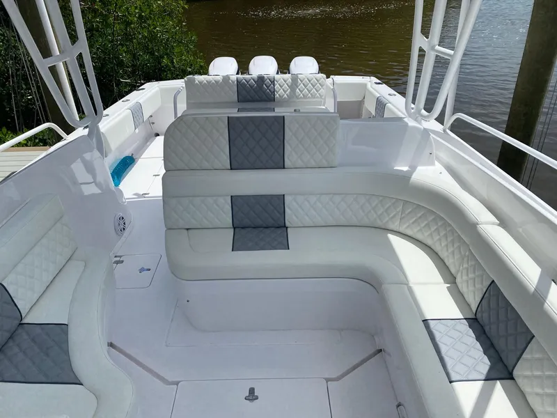 Slide: The Image of 2001 Intrepid 377 Walkaround boat interior with white and gray seating, docked by water. - 24