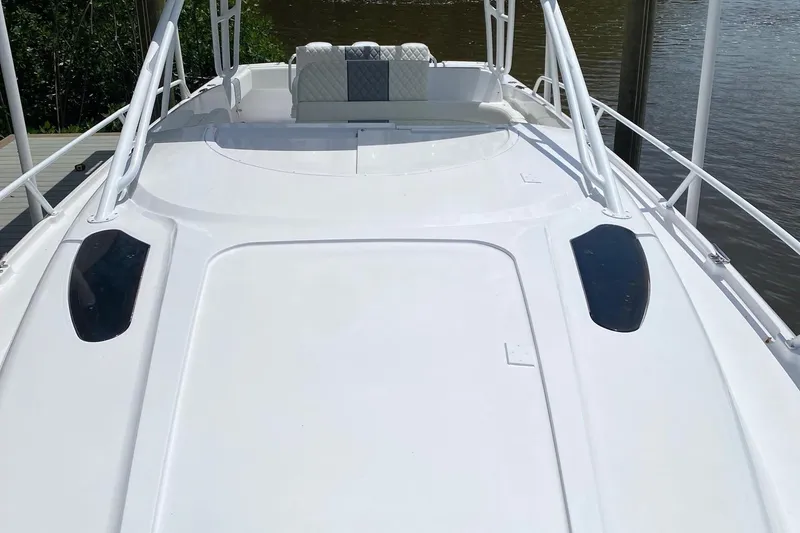 Slide: The Image of 2001 Intrepid 377 Walkaround boat deck with seating, docked by water. - 27