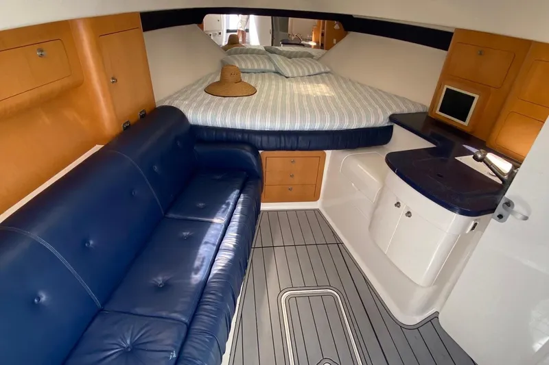 Slide: The Image of 2001 Intrepid 377 Walkaround cabin with blue seating, bed, and wooden accents. - 33