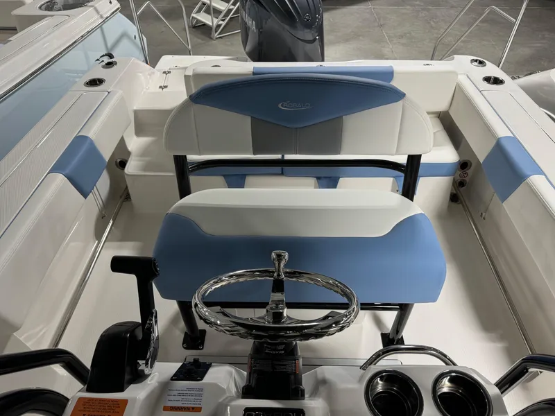 Slide: The Image of 2025 Robalo R202 Explorer boat interior with blue and white seating and steering wheel. - 11