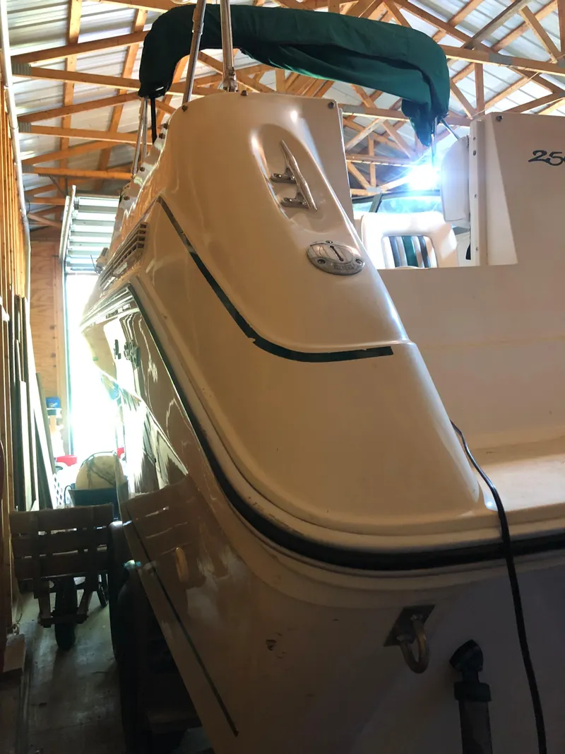 Slide: The Image of 1991 Sea Ray 250 Weekender boat in storage, showcasing sleek design and white exterior. - 10