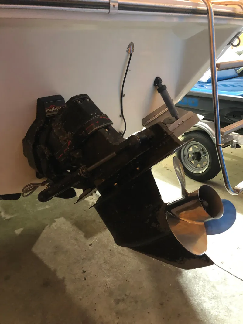 Slide: The Image of 1991 Sea Ray 250 Weekender boat stern with propeller and outboard motor. - 11