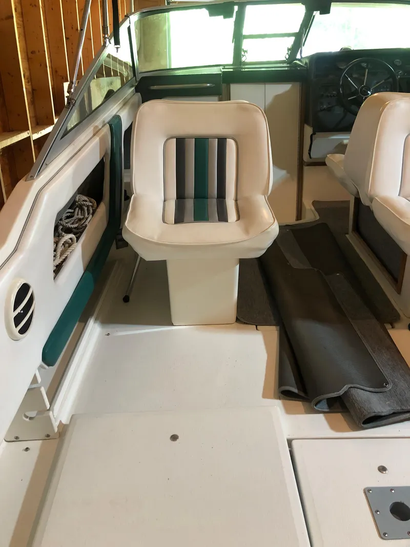 Slide: The Image of 1991 Sea Ray 250 Weekender interior with white seating and striped accents. - 15