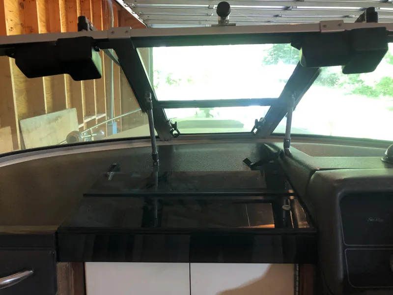 Slide: The Image of 1991 Sea Ray 250 Weekender boat interior with open windshield in a garage. - 17