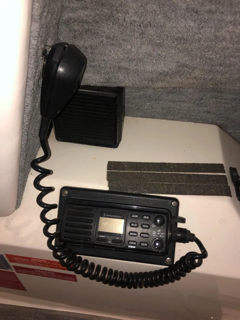 Slide: The Image of VHF radio system on 1991 Sea Ray 250 Weekender boat, featuring microphone and speaker. - 27