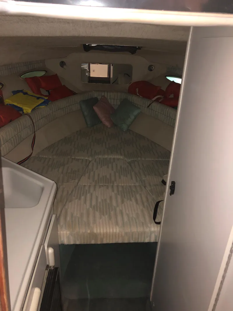 Slide: The Image of 1991 Sea Ray 250 Weekender cabin interior with cozy bedding and colorful pillows. - 33