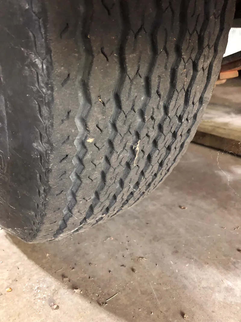 Slide: The Image of Worn tire on a 1991 Sea Ray 250 Weekender trailer, showing tread wear. - 7