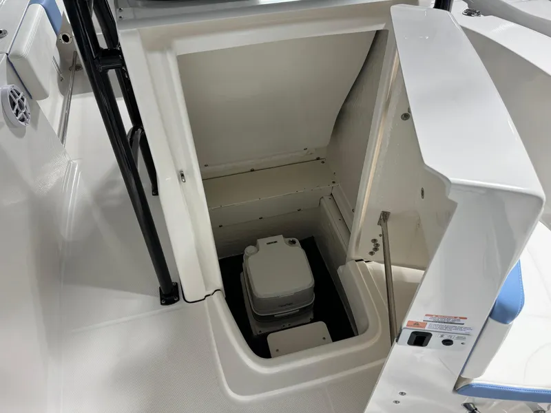Slide: The Image of 2025 Robalo R202 Explorer boat interior with storage compartment and portable toilet. - 11