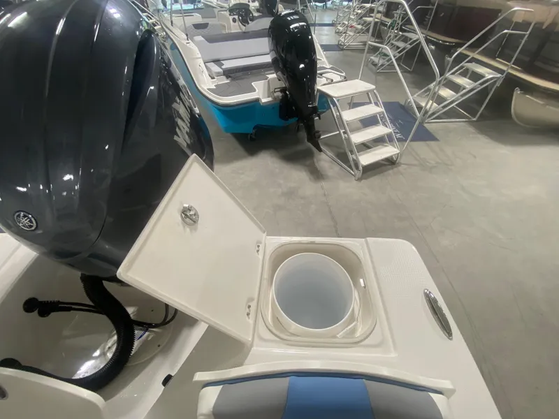 Slide: The Image of 2024 Robalo 206 Cayman boat with open storage compartment and outboard motor in showroom. - 10