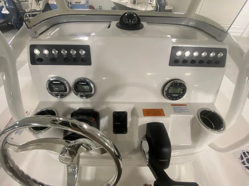 Slide: The Image of 2024 Robalo 206 Cayman boat dashboard with steering wheel, controls, and gauges. - 11